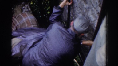 1961: A Man Helps Another Man Kiss the Blarney Stone in Dublin, Ireland