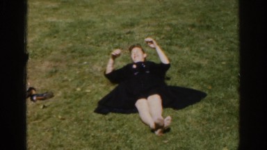 1961: a woman in a dress doing situps in a field of grass IRELAND