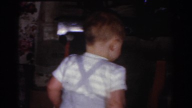 1968: Toddler Boy in Suspenders Walking Around Christmas Tree Omaha Nebraska