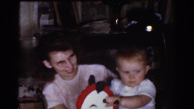 1968: mom playing with baby on hobby horse OMAHA NEBRASKA