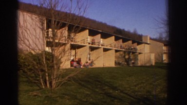 1971: a large building having a vast meadow in the yard near to a mountain