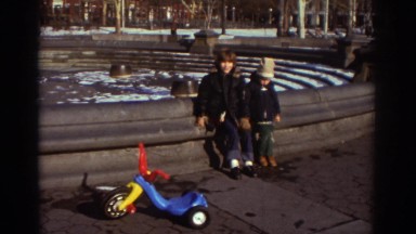 1971: two young boys sit on the outside edge of an empty water fountain
