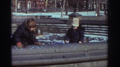 1971: two children play in an empty water fountain pool in the winter