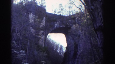 1971: a man walks down a road towards a large hole in a wall front RICHMOND