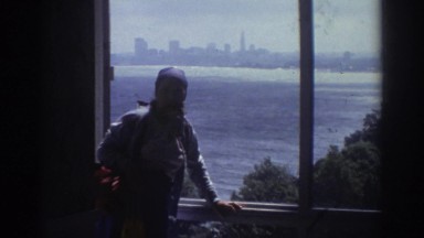 1974: Woman Standing in Window, River, Enjoying City Skyline View