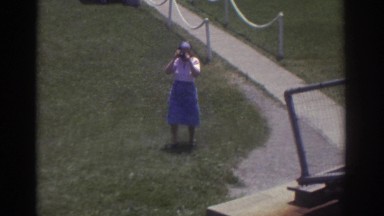1974: a woman is walking towards the video camera with a photo camera