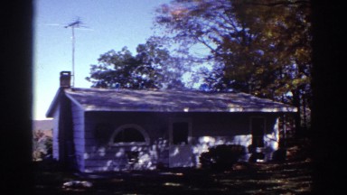 1976: white cottage on mountain wit tv antenna and half round window WATKINS