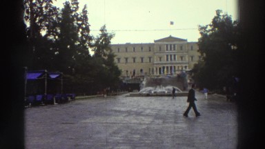 1976: Couple Walking in Rain with Red Umbrella in Greek Park
