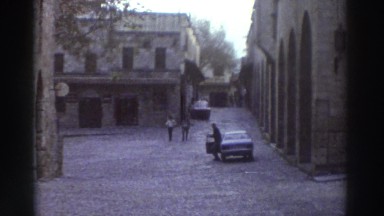 1976: A Kid Throwing Newspaper on a Street as a Man Leaves His Car