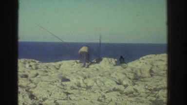 1976: Two Men Fishing Along a Rugged Rocky Coastline in Greece