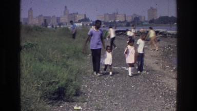 1976: family holding hands and enjoying the beach near a city HARLEM NEW YORK