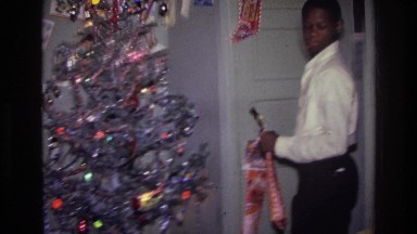 1976: a man busy decorating the house for christmas, looking for a proper place