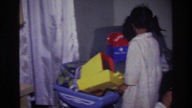 1976: little girl collecting her toys. HARLEM NEW YORK