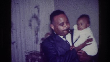1976: proud father carrying his baby. HARLEM NEW YORK