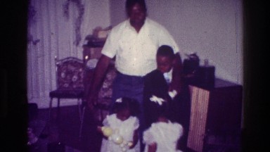 1976: little girl walking over to father, sister, and brother to take a family