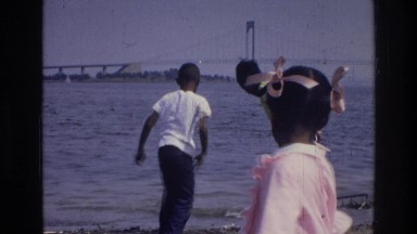 1976: group of children on the beach, searching for worms in the dirt. HARLEM