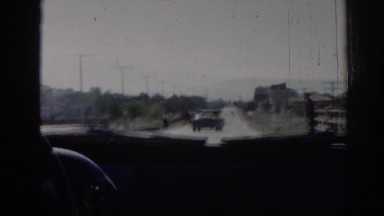 1962: view from the inside of a car driving down a small straight road. IZMIR