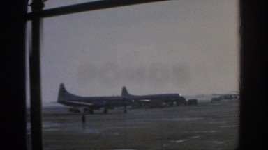 1963: a view of multiple airplanes at an airport from inside a building MUNICH
