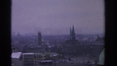 1963: An aerial view of fog or smog covered buildings in a city or large town