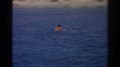 1962: a person in a lake with water skis on his feet and a rope in his hand