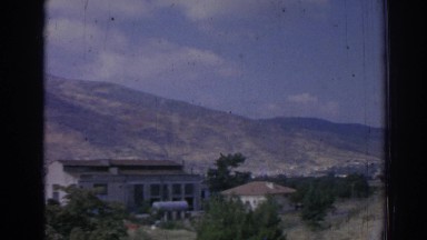 1962: people partying followed by a view of a peaceful town in a mountain valley