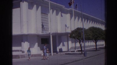 1962: the american and turkish flags in front of a large building IZMIR TURKEY