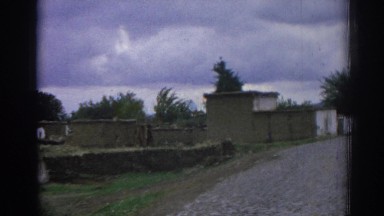 1962: old fashioned buildings in an area near to a road with pebbles IZMIR