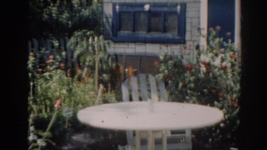 1963: white table and chair in backyard garden during a sunny day NEW JERSEY