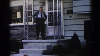 1963: a man coming out onto his porch to meet a man and a child in the driveway
