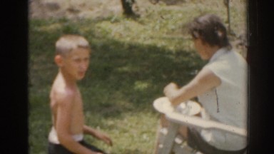 1963: mother unwraps hot tin foil off of food for son at picnic. NEW JERSEY