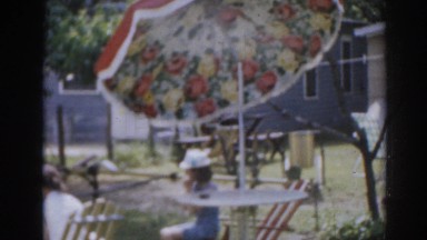1963: tender grandmother shows granddaughter the flowerbed and mother sits
