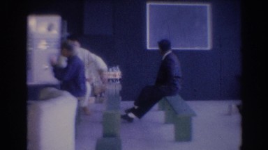 1967: man sitting on bench staring at wall, asian man walking with cup in hand