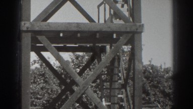 1937: an old lady is stepping down from a tower made of wood SACRAMENTO