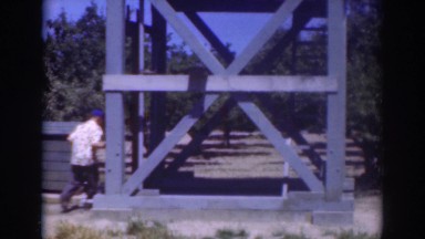 1937: a man climbs the ladder of a wooden water tower during the summer