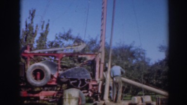 1937: people work to build a structure with a very tall mast with ropes attached