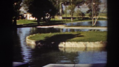 1937: a well maintained pond with rock-lined banks sits in a grassy area