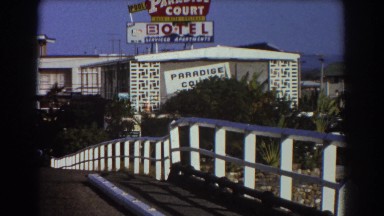 1967: a small bird sits on a power line near a motel SYDNEY AUSTRALIA