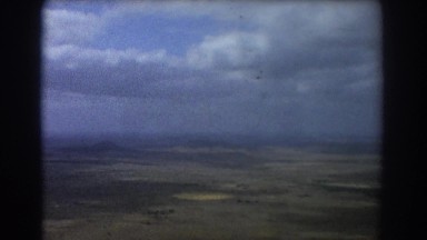 1967: surveying farm land above with airplane flying under clouds PERTH