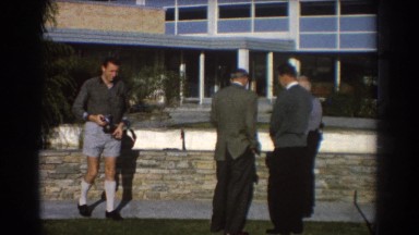 1967: people waiting near to the wall of a building with magnificent design