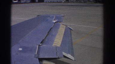 1967: angled and connected sections of airplane wing extend over airport grounds