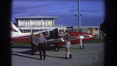 1967: men gathered around an airplane admiring it under blue sky PERTH AUSTRALIA
