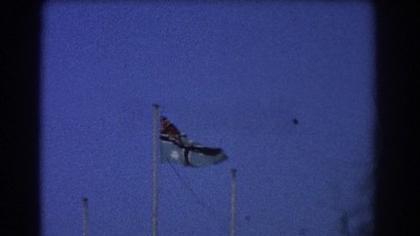 1967: flag blowing in the wind next to three empty flagpoles PERTH AUSTRALIA