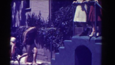 1937: woman in bathing suit climbing up staircase as other women are watching