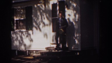 1939: A Gentleman in Hat Walking Out of House as Wife Watches
