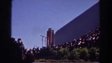 1939: a lot of people moving in queue through the side of a large structure