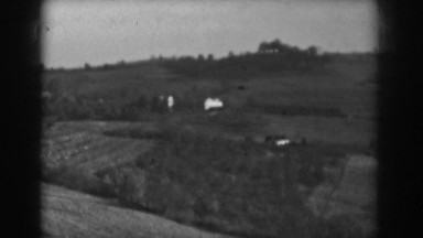 1938: a home or structure set on the side of a rolling hill in the countryside