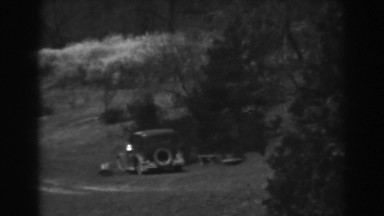 1938: a vehicle remaining parked on a hilly area with lot of bushy plants
