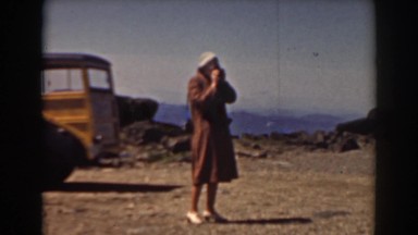 1938: woman takes photos of person leaning against building