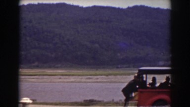 1938: a truck is parked next to a river while a horse and buggy go by