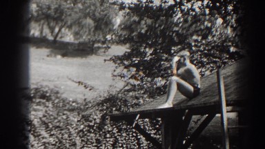 1938: Adolescent Male Enjoying Warm Summer Day Perched on Roof